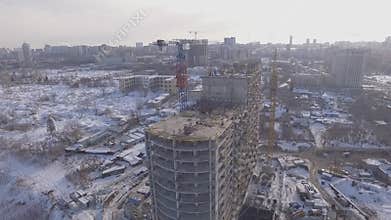 Constructing building in big city, aerial view in winter day