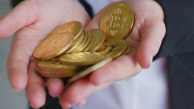 Crop female in black formal jacket holding handful of shiny bitcoins
