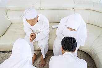Young people bowing to their old parents