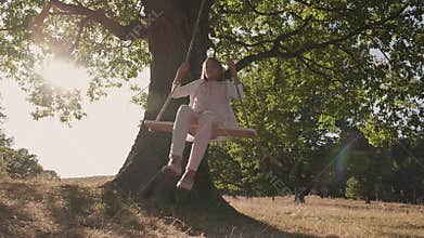 Girl enjoy spinning on rope swing with hair flowing