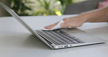 Close up view of woman hand using antibacterial wet wipe for disinfecting laptop
