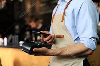 Customer using credit cart for payment to owner at cafe restaurant, cashless technology and credit card payment