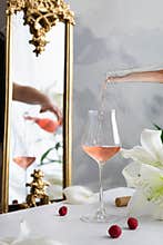 Pouring pink rose wine into a glass. Celebration, wedding party, happy birthday, St. Valentin`s Day concept. Pink wine tasting.