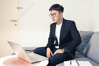 Young Asian business man with using laptop computer for video conferencing while working at home. Work from home and Social