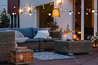 Evening on the patio of beautiful suburban house with lights in the garden garden