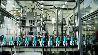 Automated filling plastic bottles on cosmetic conveyor. Manufacture cosmetics