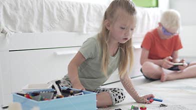 The baby collects the designer, the older brother plays in the phone.