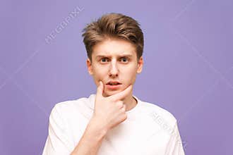 Close up portrait of a thoughtful young man wearing a white T-sh