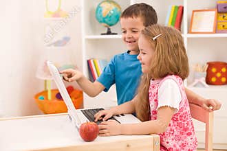 Kids playing on laptop computer at home