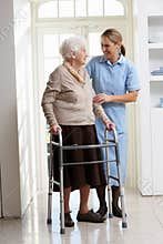 Carer Helping Elderly Senior Woman Using Walking F