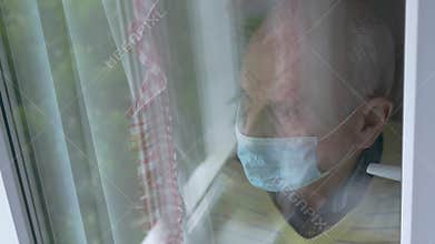 Depressed old man in mask reflection in window overhead view