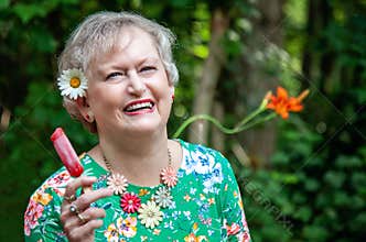 Happy senior woman with popsicle during summer
