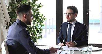 Confident caucasian businessman handshaking male arab partner at meeting