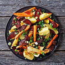 Roasted sliced veggies on a black plate