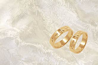 Gold wedding rings on white festive background