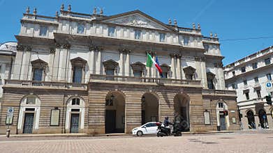 Milano, Italy. The facade of the famous La Scala Theater. Few people in the street because of the Covid-19 Coronavirus