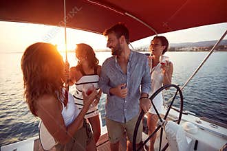 Friends  drinking on a yacht and enjoying at vacation and luxury travel at sunset