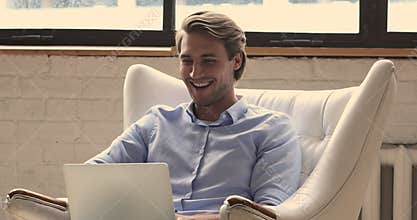 Man sit in armchair use laptop read email feels happy