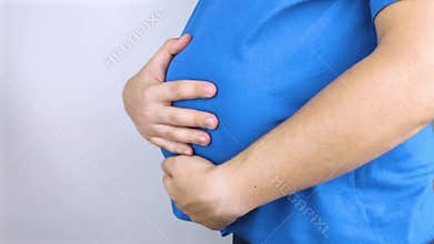 The man is holding onto his swollen belly. Bloating, flatulence, gas, malfunction of the gastrointestinal tract. Conceptual video