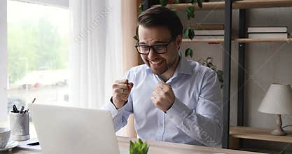 Happy young man in eyeglasses getting email with good news.