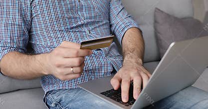 Close up young man entering payment data in computer application.