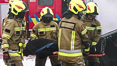 Firefighters rescuing person from car crash accident