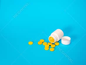 Yellow pills and plastic white bottle