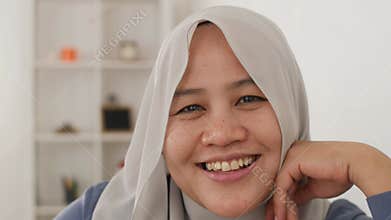 Happy Asian muslim woman smiling cheerful, woman relaxing in her living room