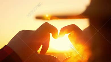 The girl shows the gesture of the heart with her hands. Heart symbol with child hands. Happy man shows love. The sivol