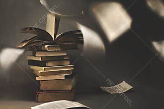 Surreal stack of vintage books where the pages flutter free