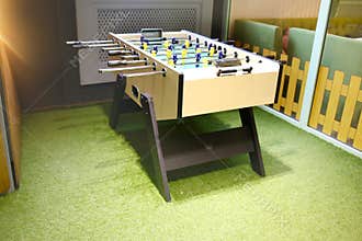 Children`s game - table football with figures of football players of both teams in a wooden box in the playroom for teenagers.
