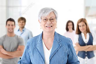 Happy senior teacher with students in background