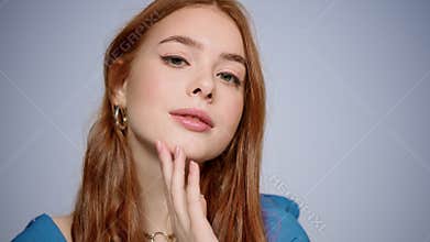 Pretty girl flirting in studio in slow motion. Woman touching face indoors