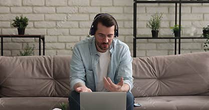 Man in headphones having pleasant distant conversation by video call
