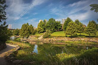 Tulsa USA - Skyscrapers of downtown Tulsa viewed over lake and trees of Centenial Park on beautiful summer day