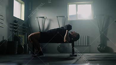 Athletic man lift dumbbells at gym .