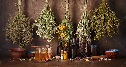 Drying medical herbs, honey, spices and bottle with essential oil for use in alternative medicine