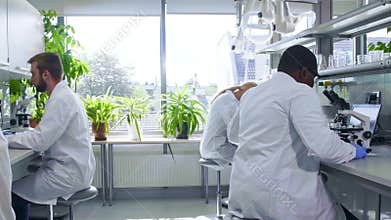 Scientist working in lab. Doctors making medical research. Laboratory tools: microscope, test tubes, equipment