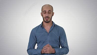 Casual arab man talking to camera explaining something on gradient background.