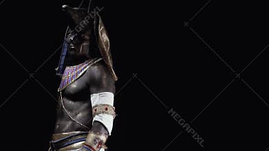 Muscular man dressed as Anubis with body art and makeup