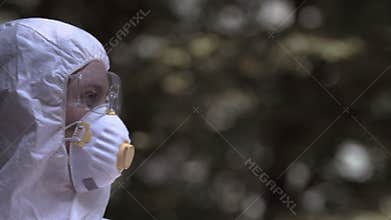Person in protective clothing turning to camera, outbreak of contagious disease