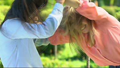 Furious female ex-friends fighting hard and pulling hair in park, catfight