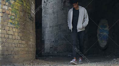 Sad bored young man walking city alone, street lifestyle, troubled teenager