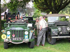 Men talking around old military vehicles in the public park at hebden bridge annual vintage weekend