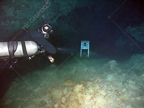 A Cave Diver Points Out Danger Sign