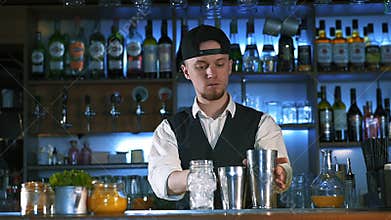 Guy-bartender starts his master class of preparation an alcohol cocktail.