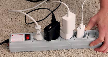 Hands turn off and unplug wires from electricity switch