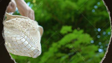 Responsible woman with eco bag throwing garbage into waste bin, bottom view