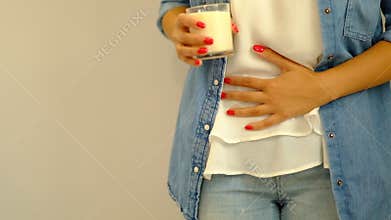 Slow motion. Healthcare and medical concept.. Woman hand holding glass of milk having bad stomach ache because of