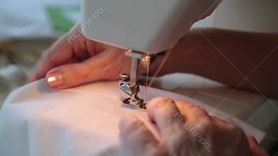 Stitching on electric sewing machine of white material. Technology